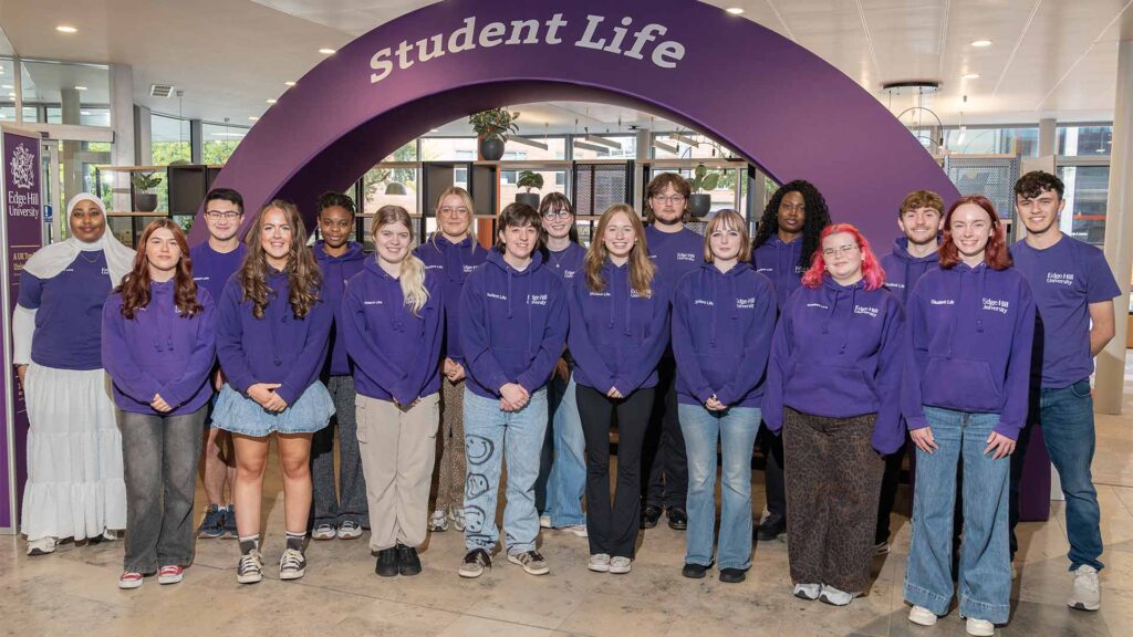 group shot of student life's campus connectors for 2025, stood by the student life arch