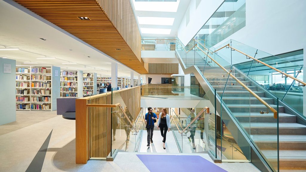 Two students walking upstairs in the Catalyst building whilst talking.