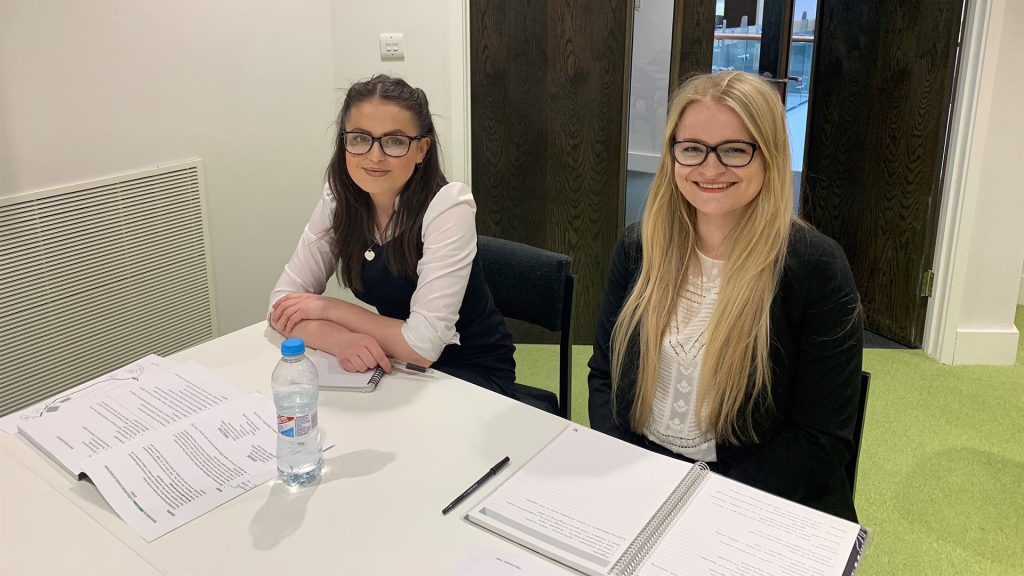 Two students sat in front of a table at the law clinic