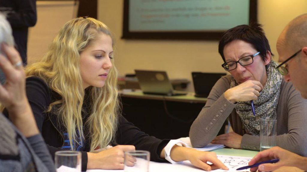 People in a meeting looking at a piece of paper