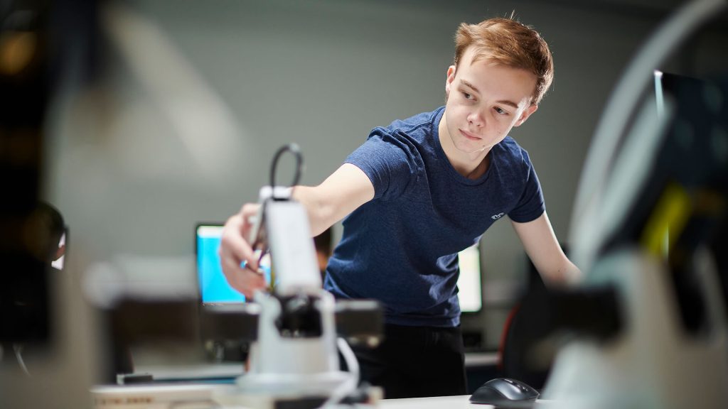 A student applies their skills in programming robots.