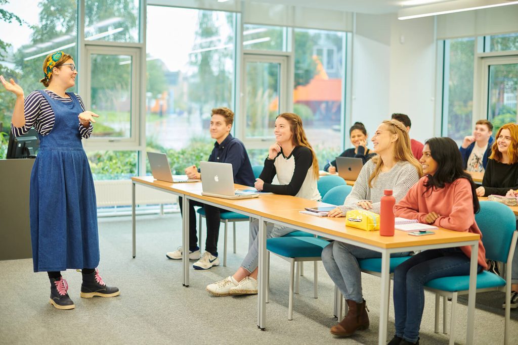 A lecturer addresses a classroom of students.