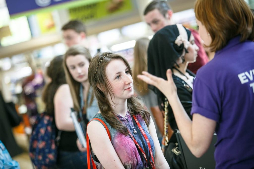 A prospective student receives advice from a member of Edge Hill staff during a UCAS exhibition.