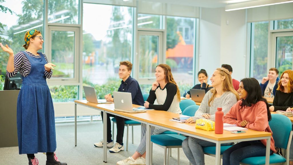 A lecturer addresses a classroom of students.