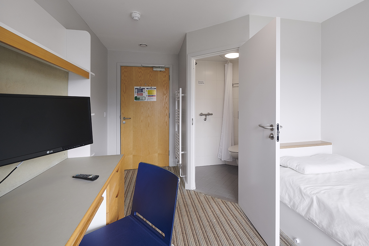 Student bedroom and en-suite shower room as seen from near the window in a Chancellors hall.