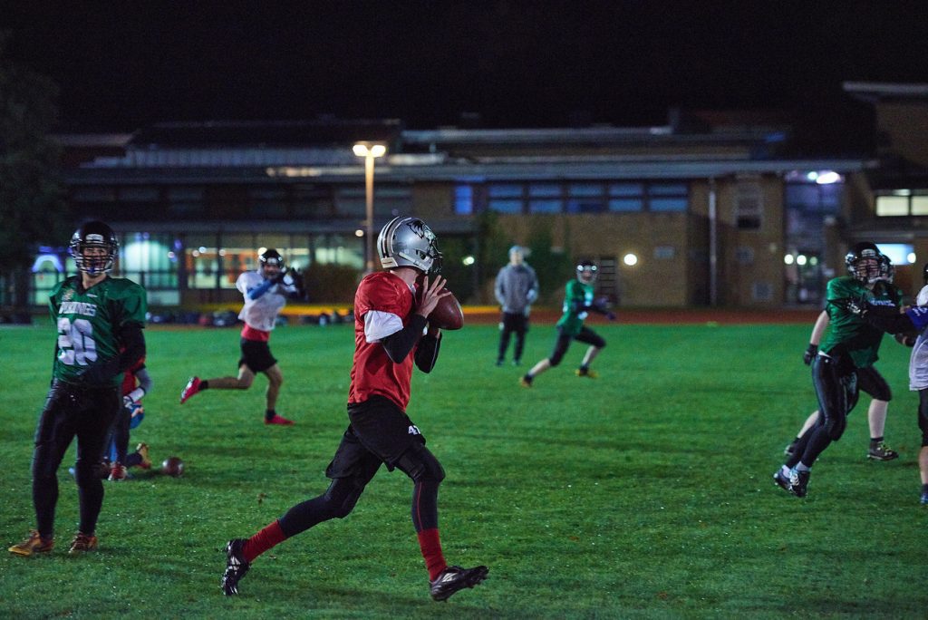 Vikings player (American football) throwing ball to teammate in a match.