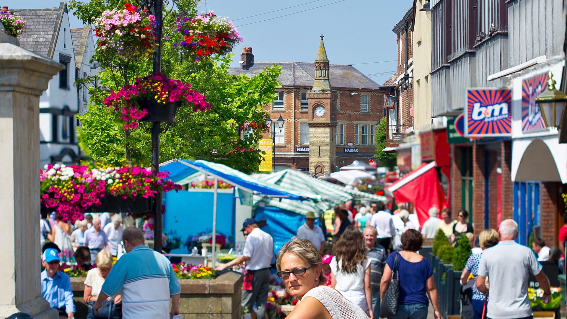 An image of the town centre of Ormskirk on a busy day, there is a large amount of people walking in the image. 