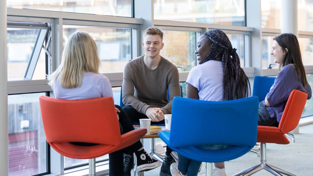 A group of students sit on chairs and talk