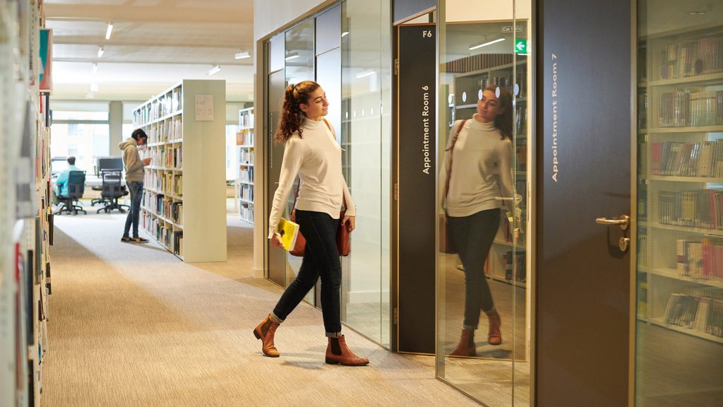 A student walking into a meeting room