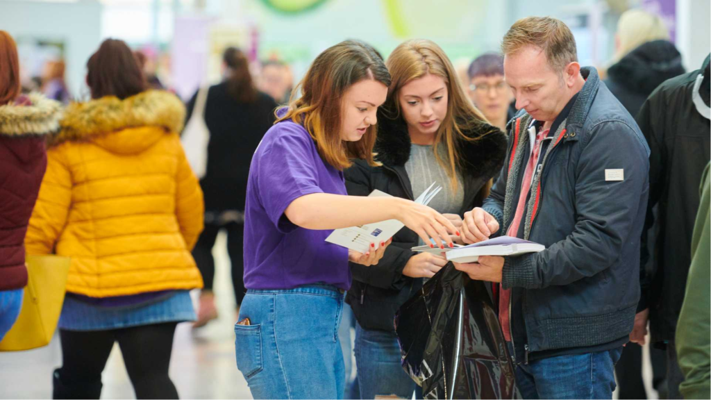An image of a student advisor helping a group of people.