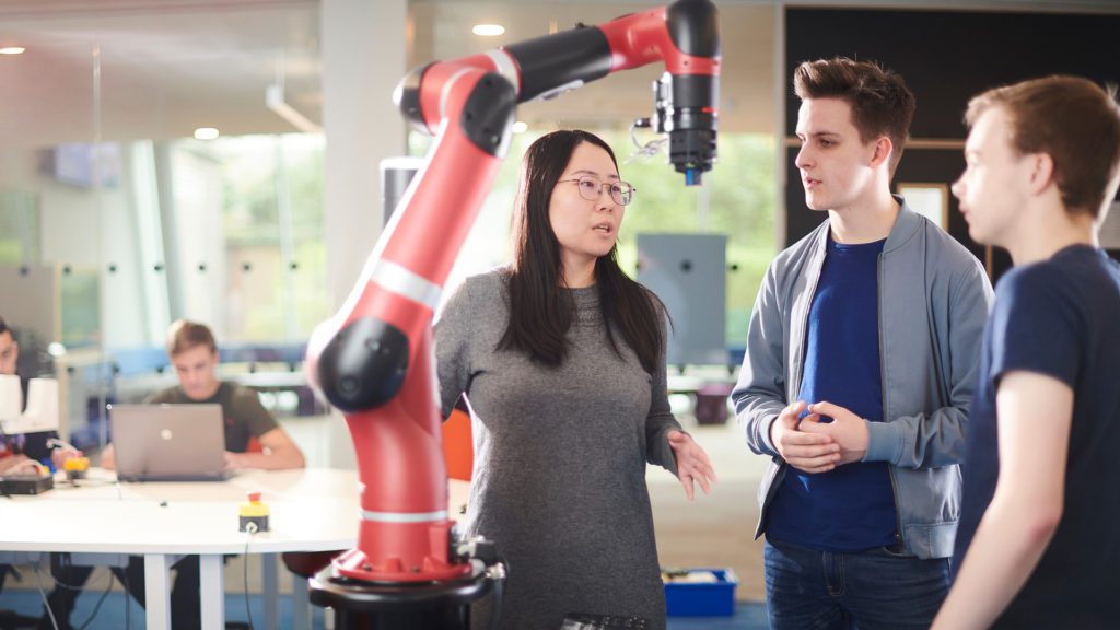Computing engineering students with robot arm