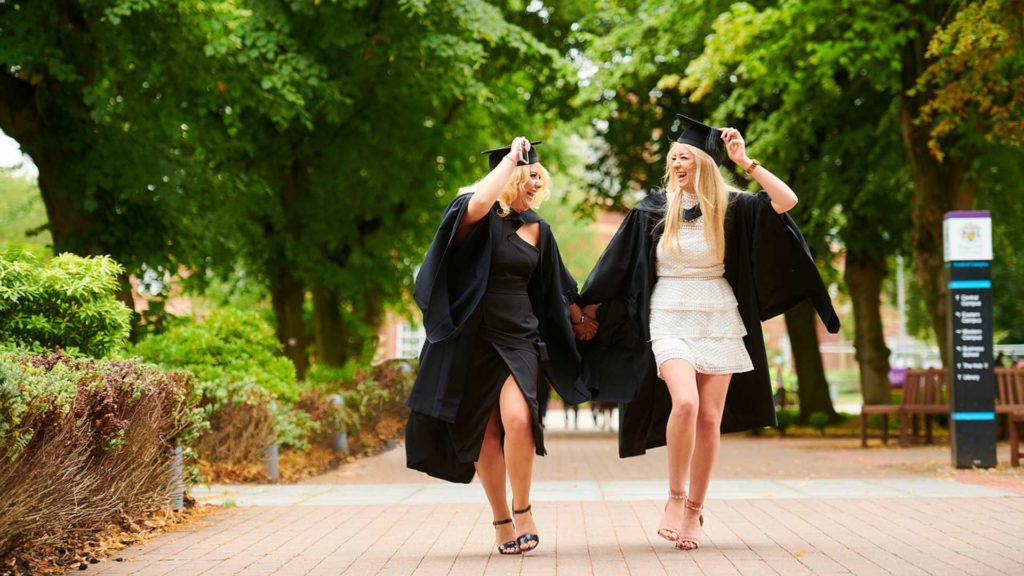 Summery graduation image with two students looking very happy