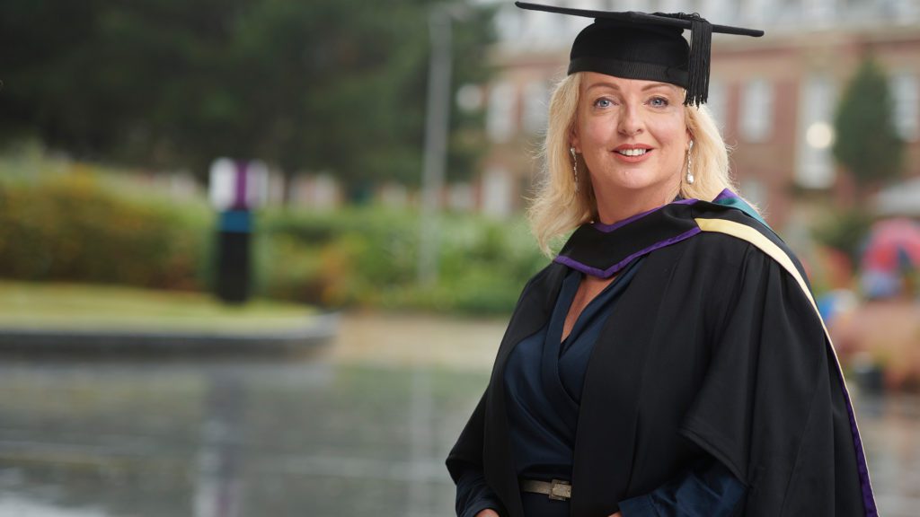 Terri Kearney wearing a cap and gown and smiling.