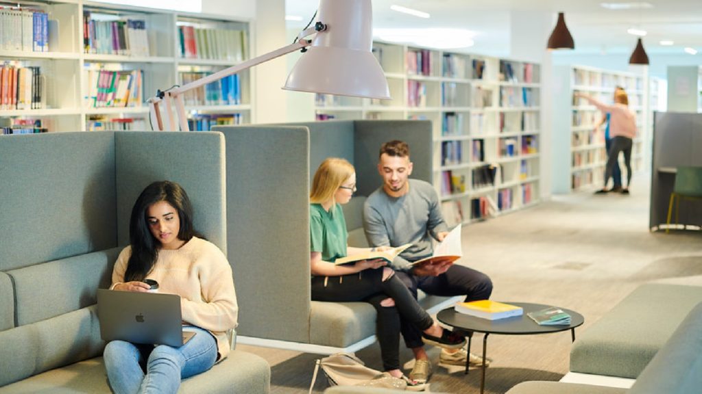Three people are sat on chairs within the University Catalyst.