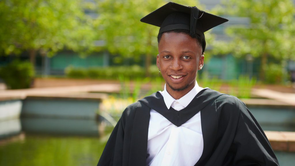 Dylan Nyoni wearing a cap and gown at graduation.
