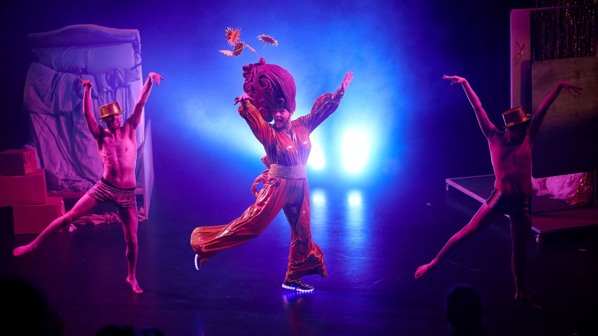An image of three people performing on a stage.