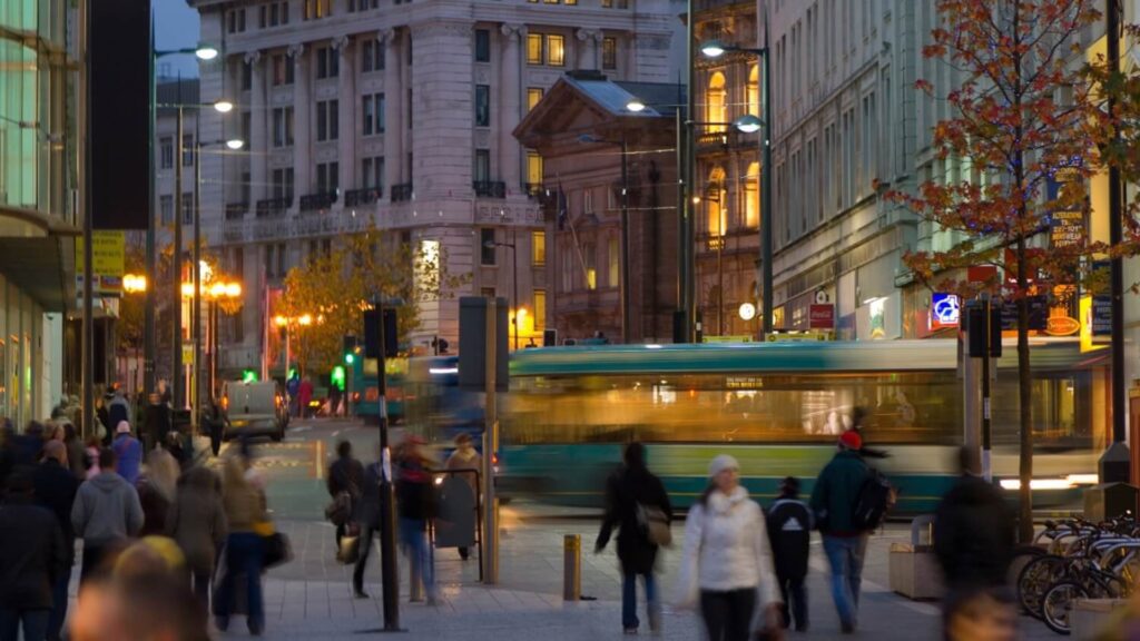 Large group of pedestrians walking through a busy town centre