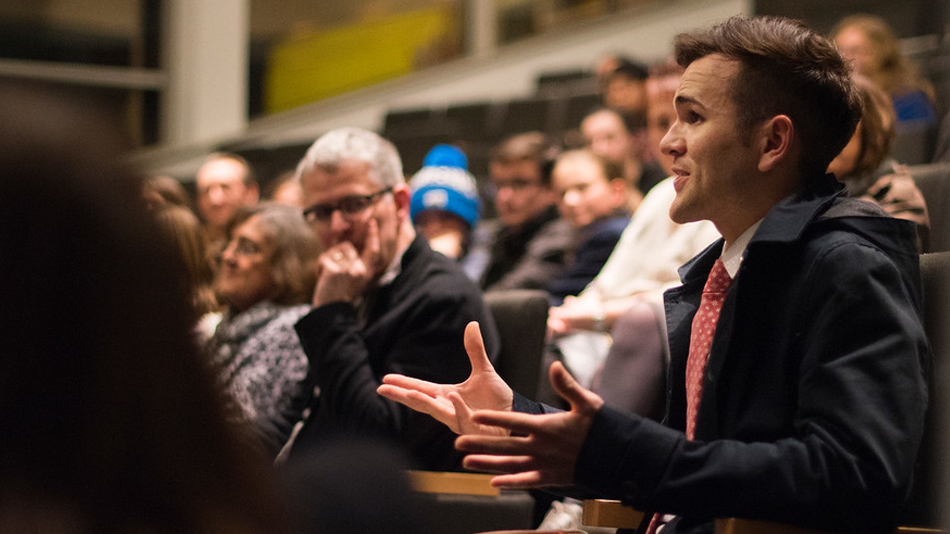 Someone asking a question form the seats of a busy lecture theatre