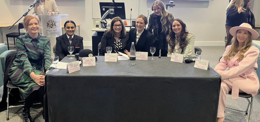 IWD Law Panel and organiser Megan Gough sat at a table smiling to camera