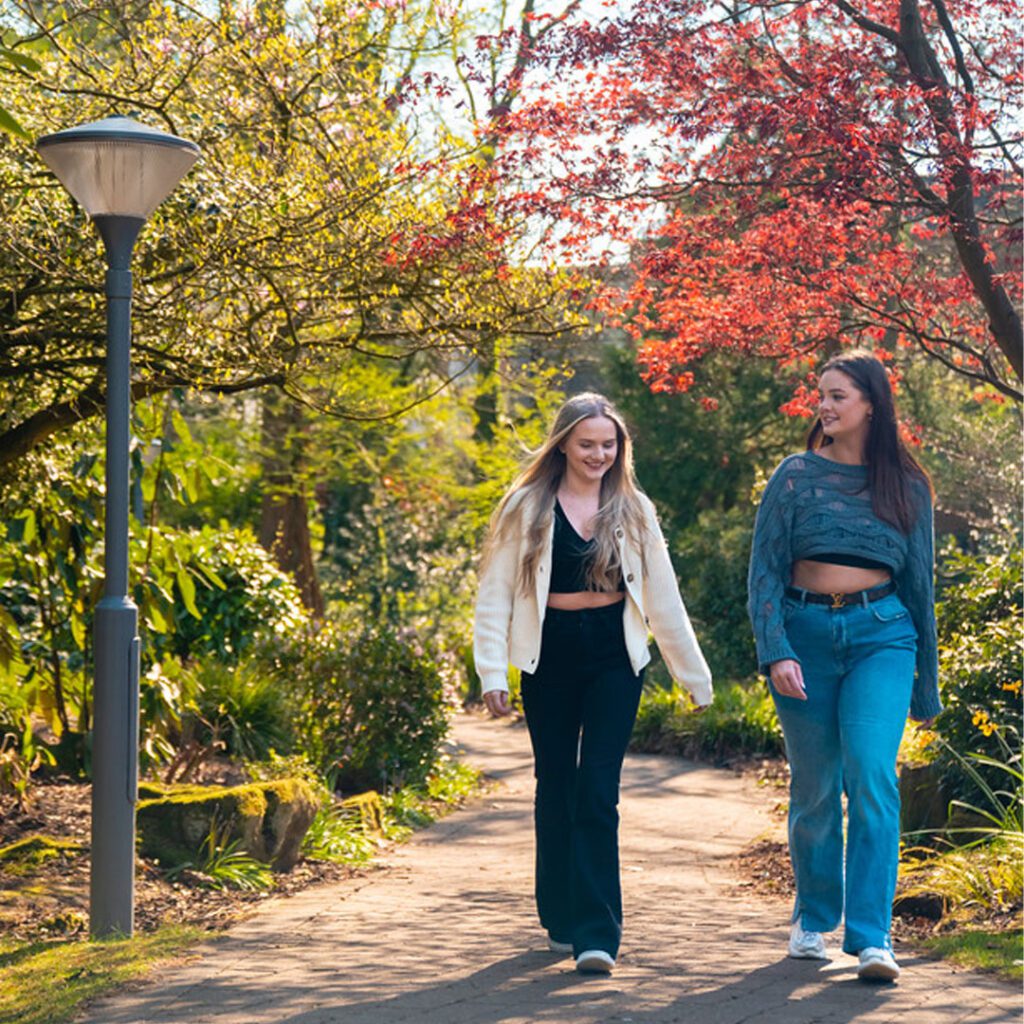 Third year students Freya and Eva walking and chatting on campus