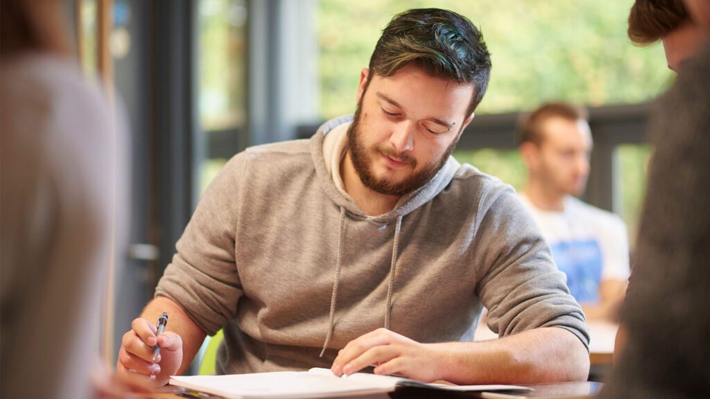 Student writing notes on a piece of paper