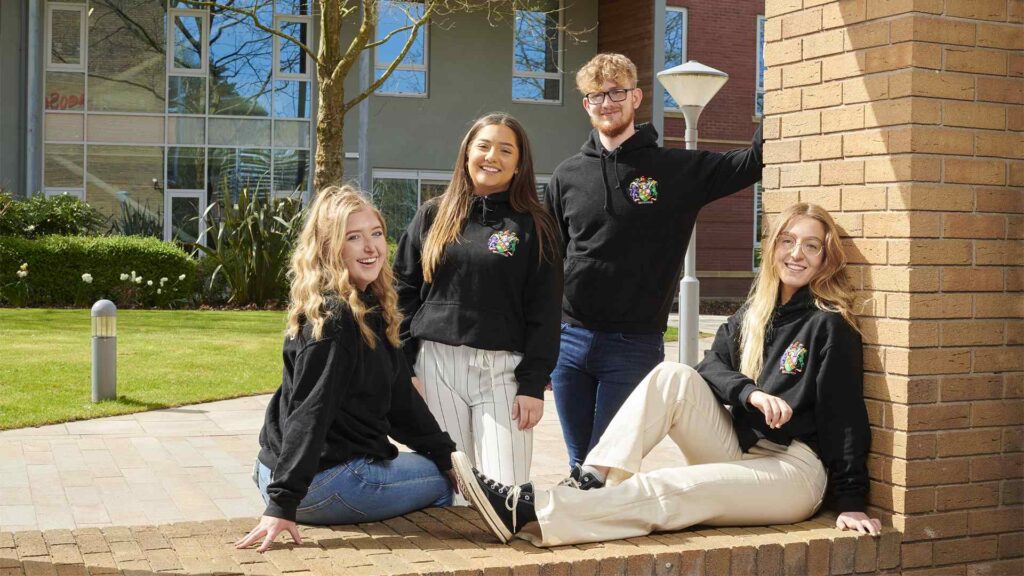 Law society students sit outside the Law and Psychology building.