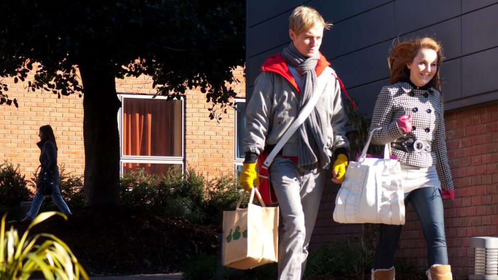 Two students carry bags of shopping near the Founders Court hall of residence.
