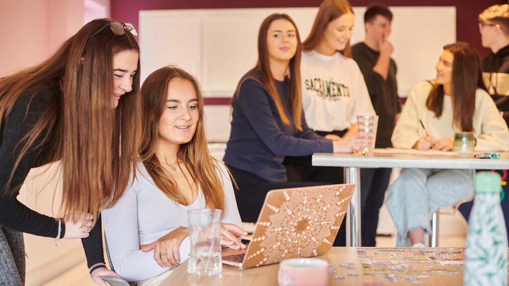 group students looking at laptop
