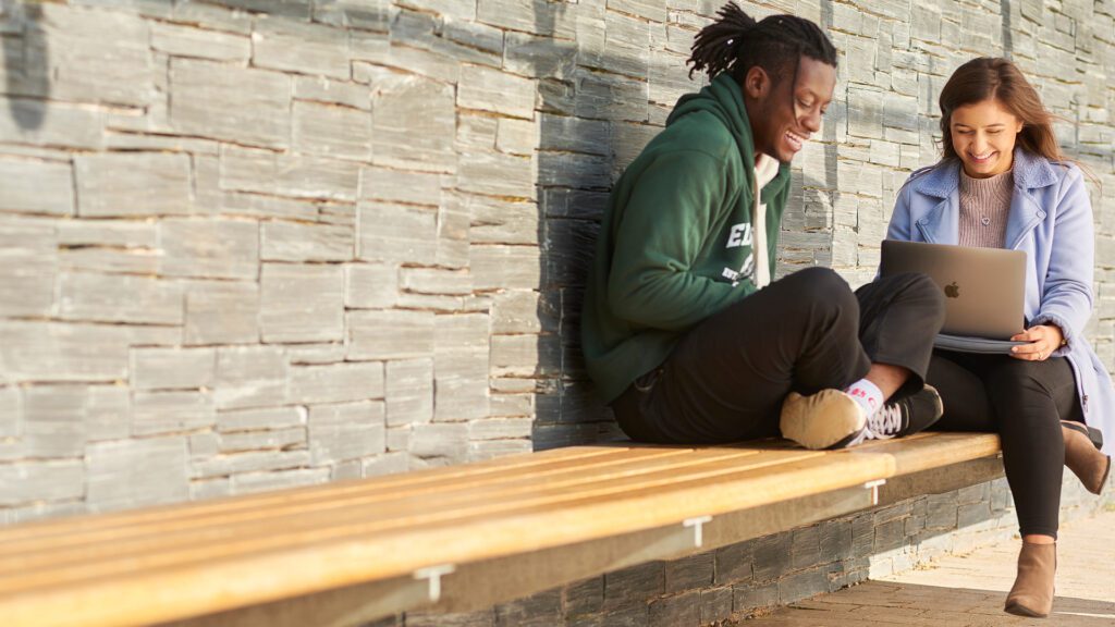 Students sat outside laughing and talking.