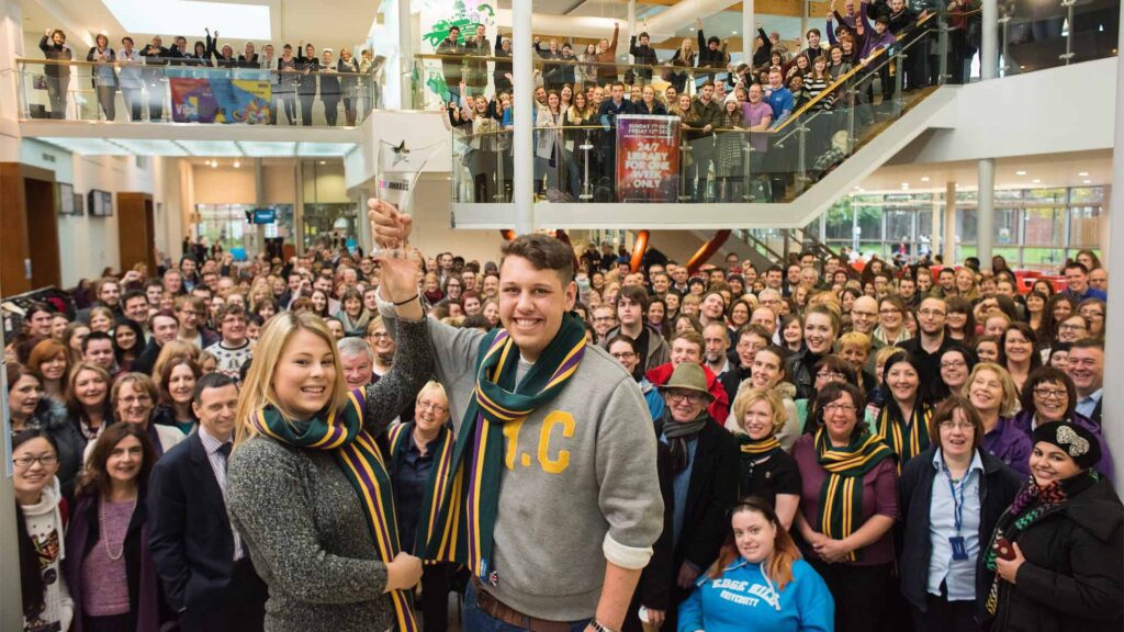 Staff and students pose in the Hub to celebrate University of the Year award