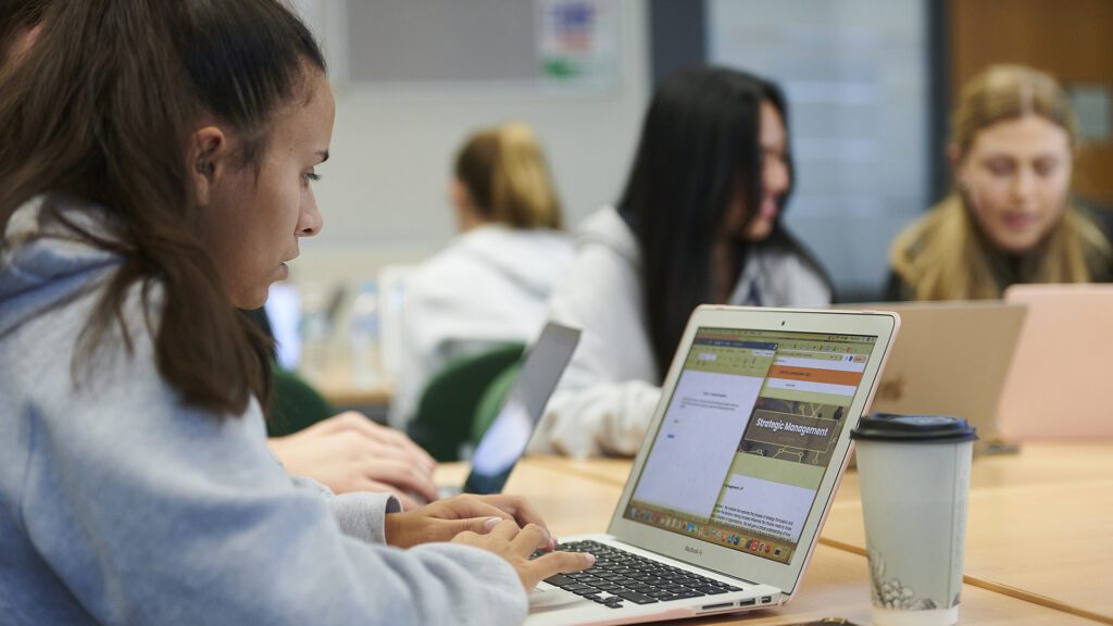Marketing student looks at analytics on a laptop
