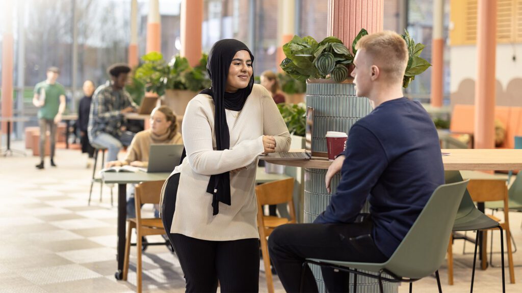 Two students talking in the Hub.