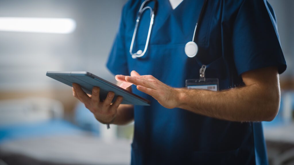 Image of a nurse using a tablet in a hospital ward.