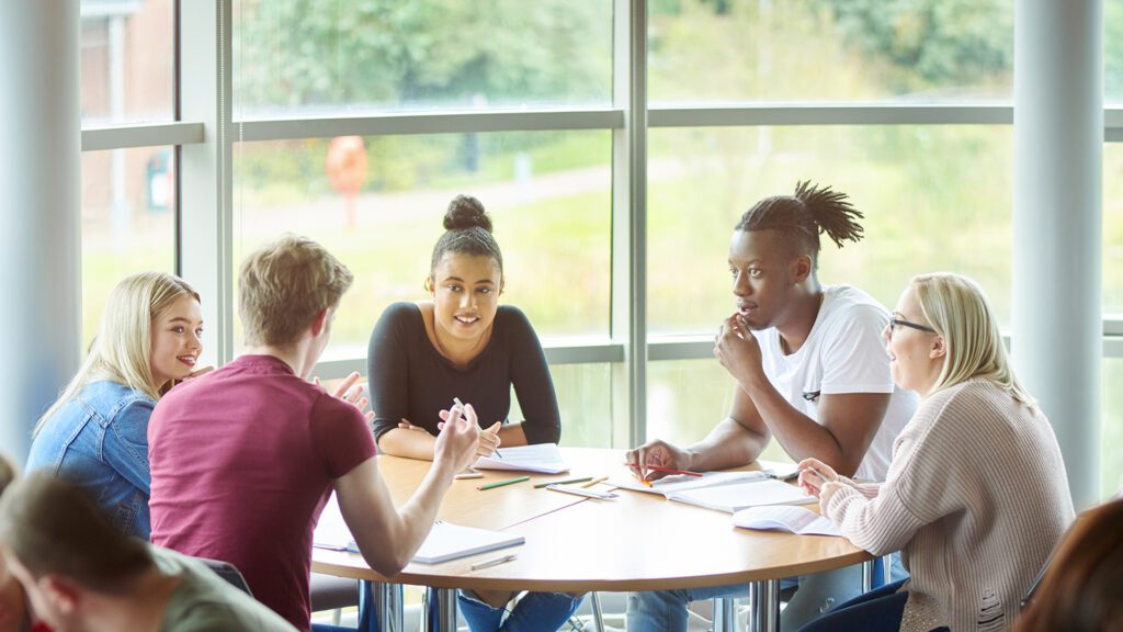 Five Philosophy students sit at a table having a discussion