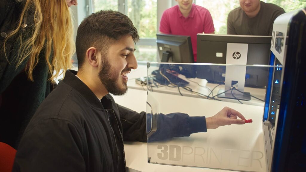 A student working in the Techhub at a 3D printer