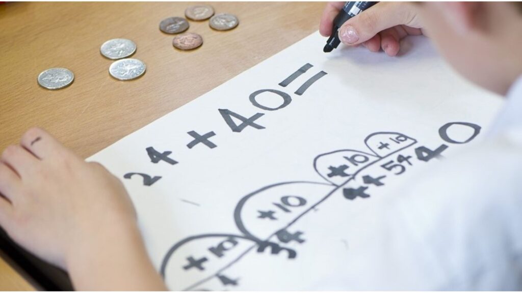 Child working on a maths worksheet task in the classroom.