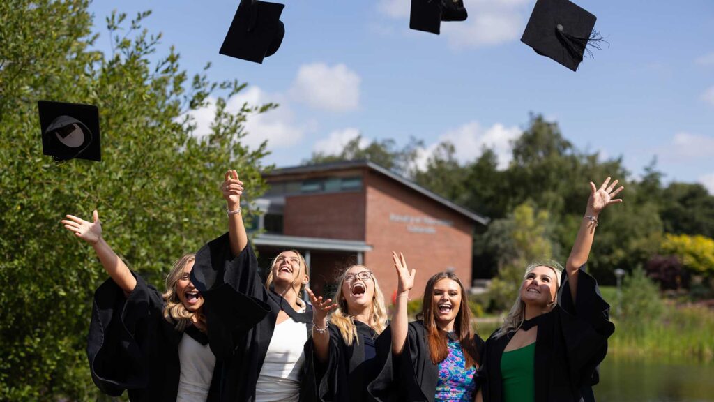 Students throw their graduation caps in the air
