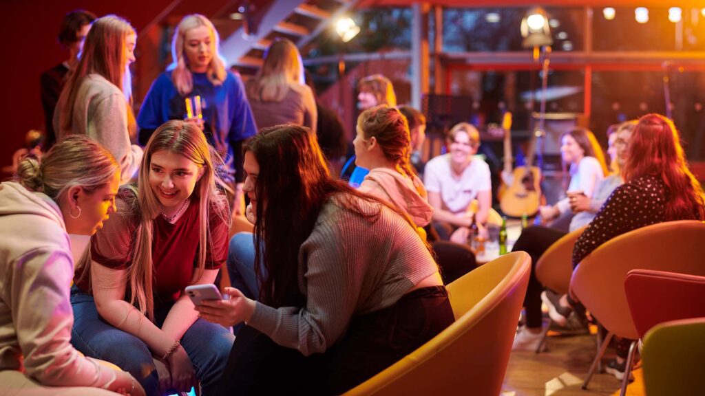 Students chatting and interacting in a bar on campus