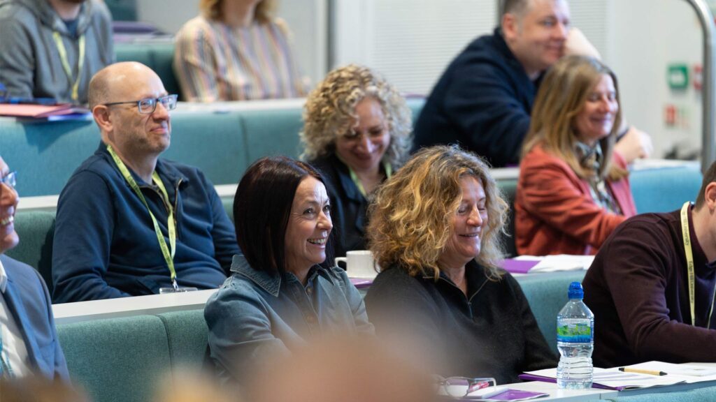Teachers, tutors and advisers in a lecture theatre listening to a session being delivered