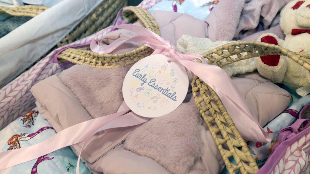 Moses basket filled with baby essentials like clothes and nappies.