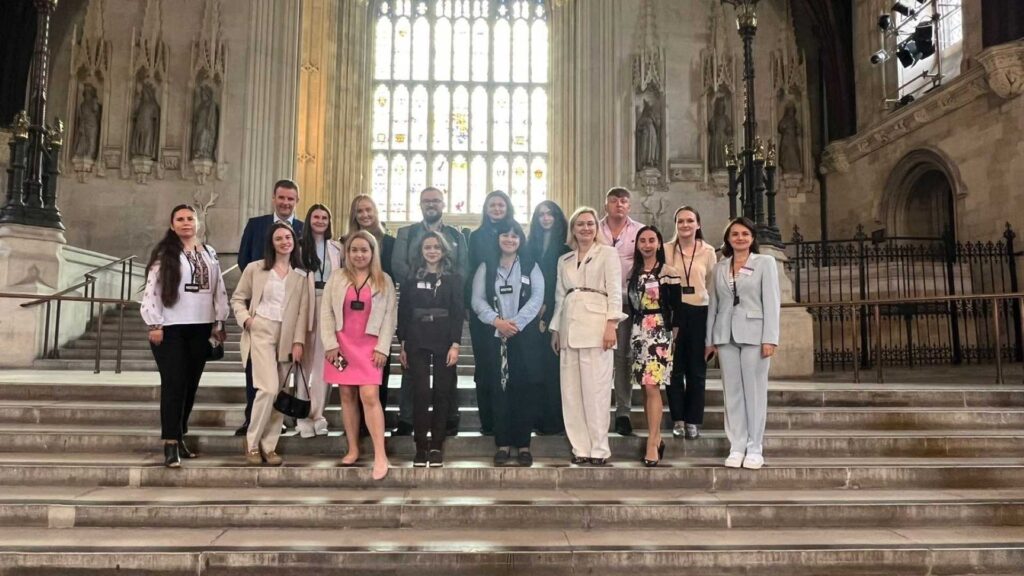 17 people standing at the top if stairs in a Cathedral in Ukraine.