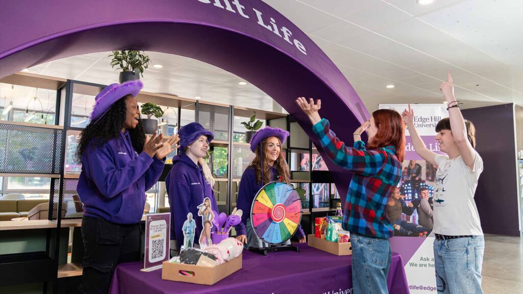 students celebrating winning a prize at the student life arch in the hub