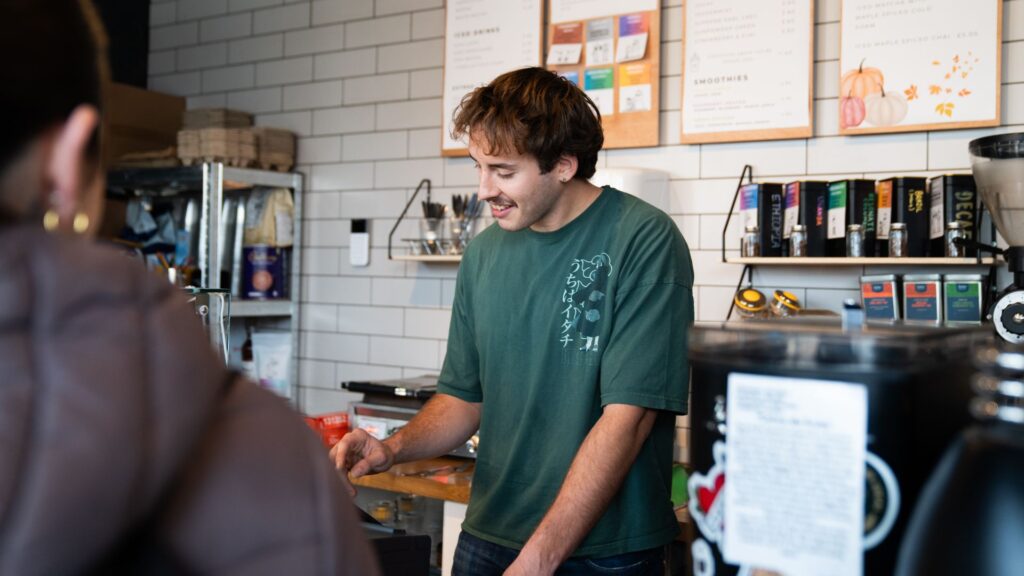 A café barrister works behind the counter