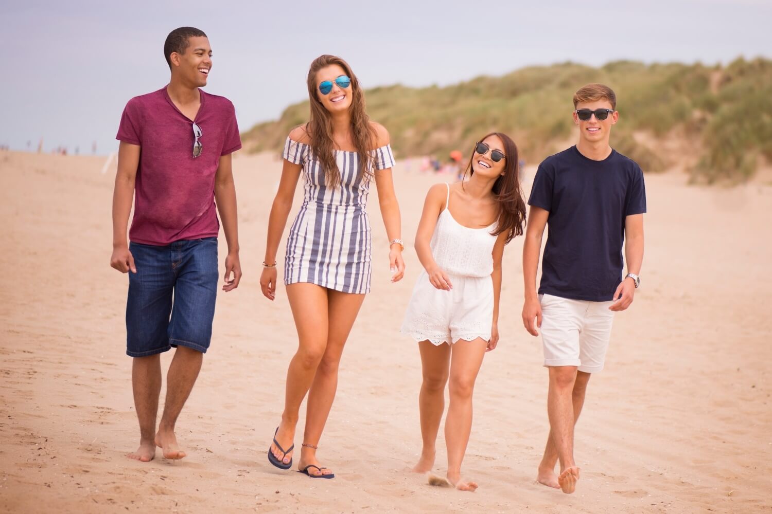 Things to do in North-West England - Four students walk through the sand dunes at Formby.