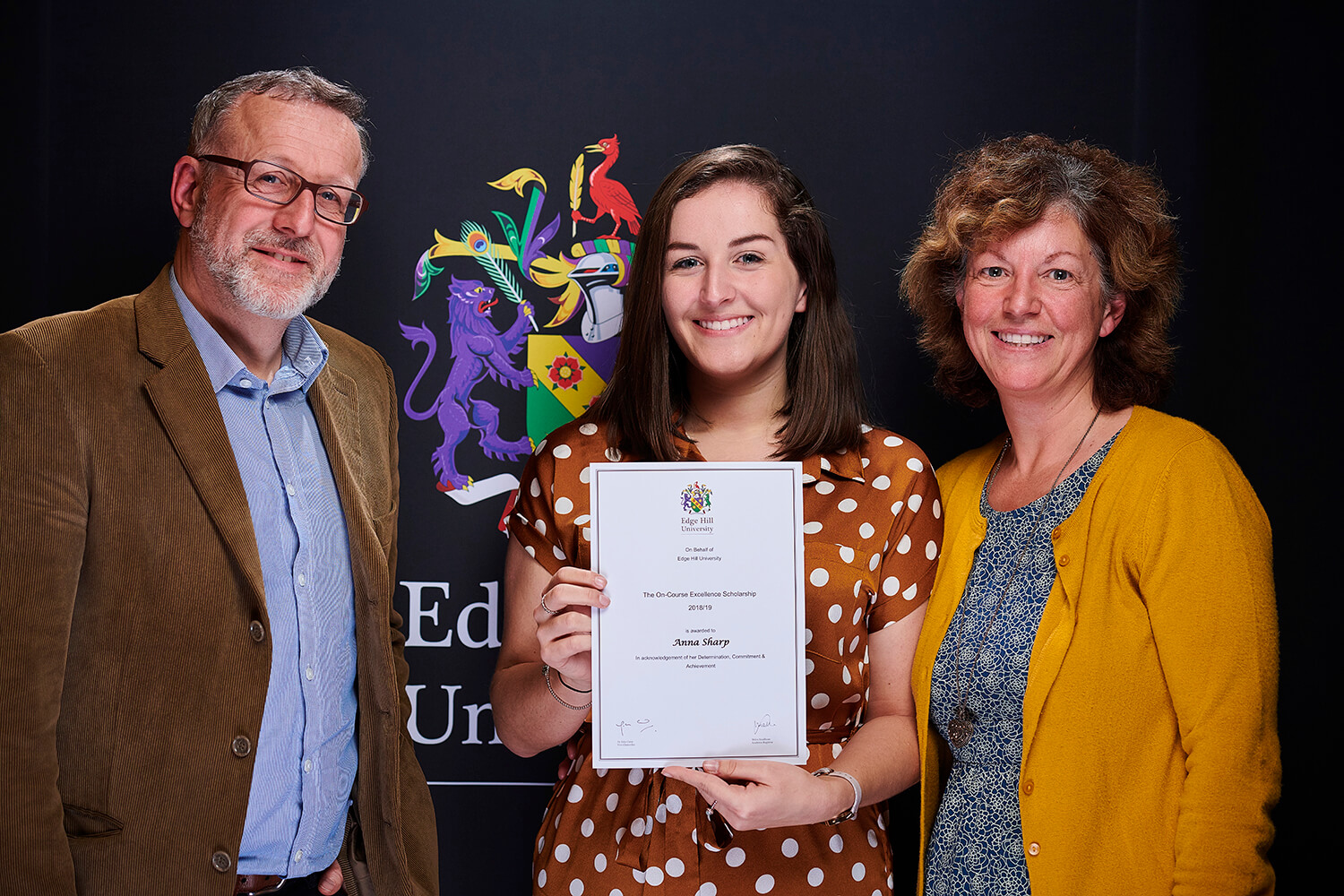 Scholarship winner Anna Sharp, with her family, shows off her certificate while attending a Scholarship Awards Evening.