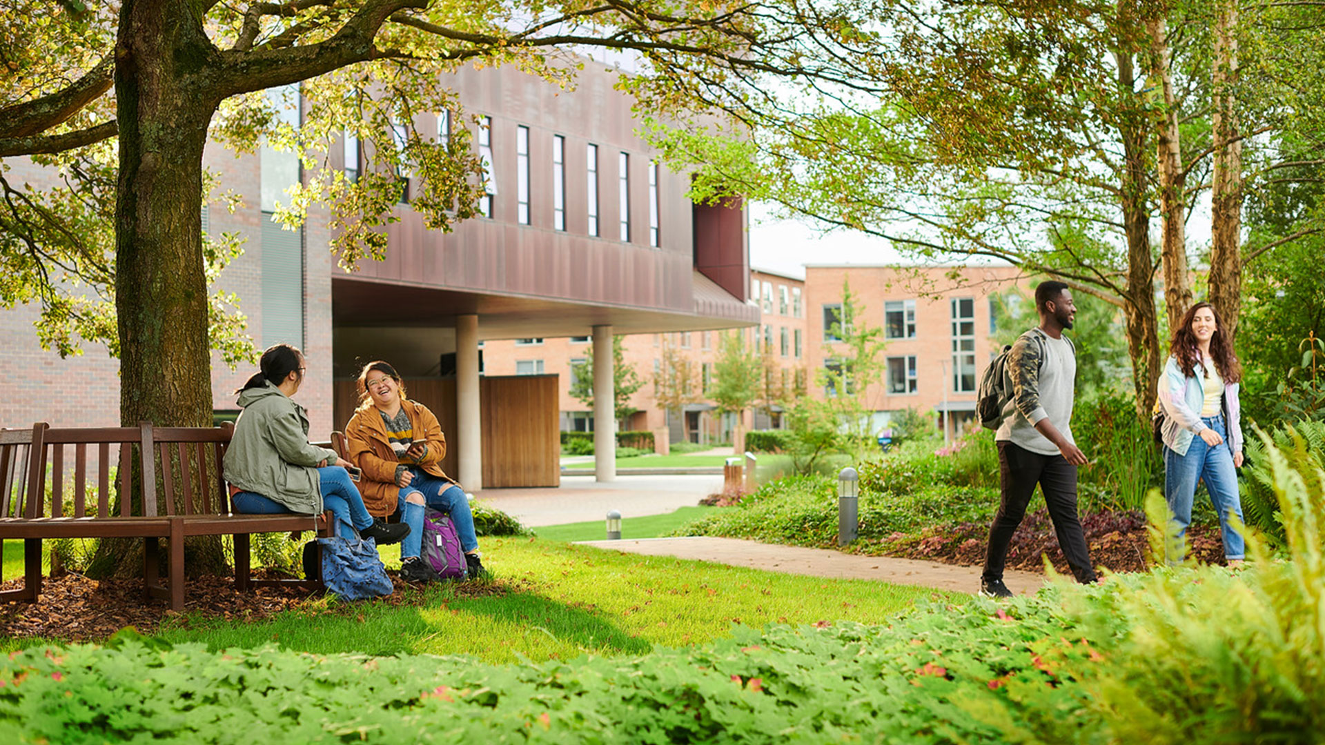 Students sitting and walking through campus by the Catalyst