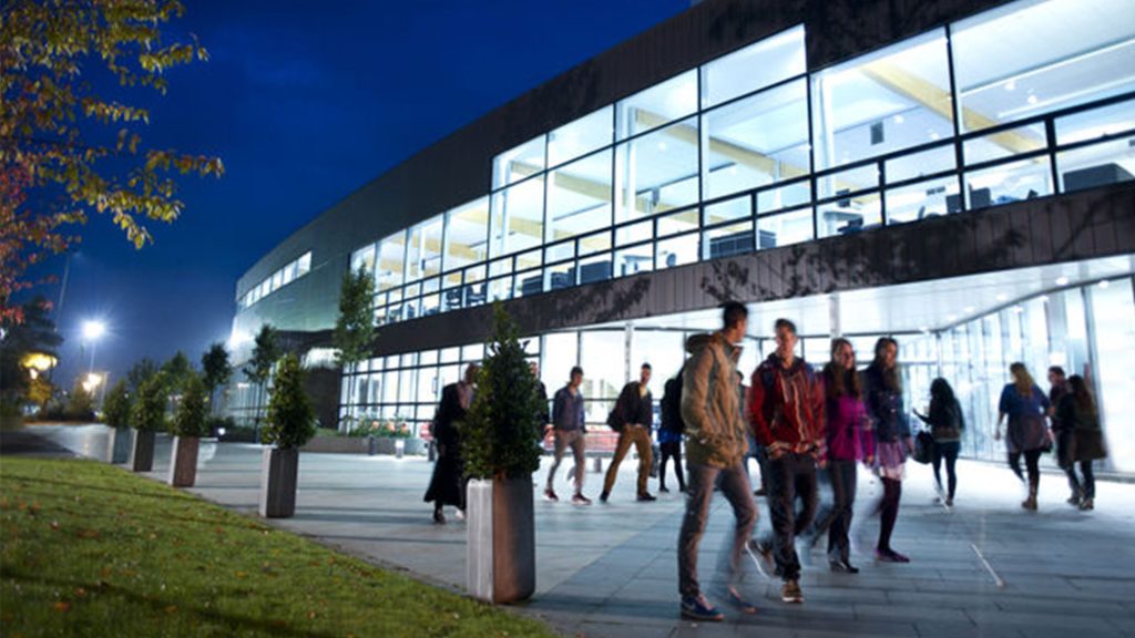 Students walking outside hub at nighttime