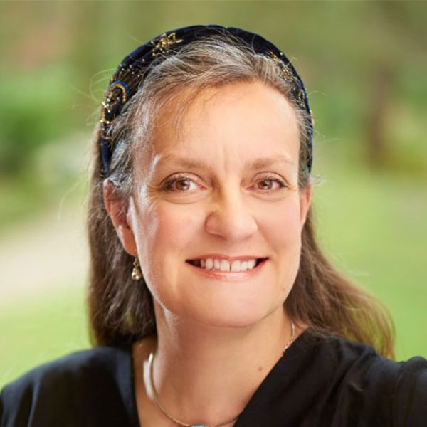 Professor Alyson Brown, smiling in front of a green background