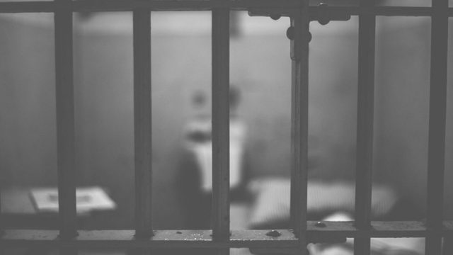 A person seen through bars in a jail