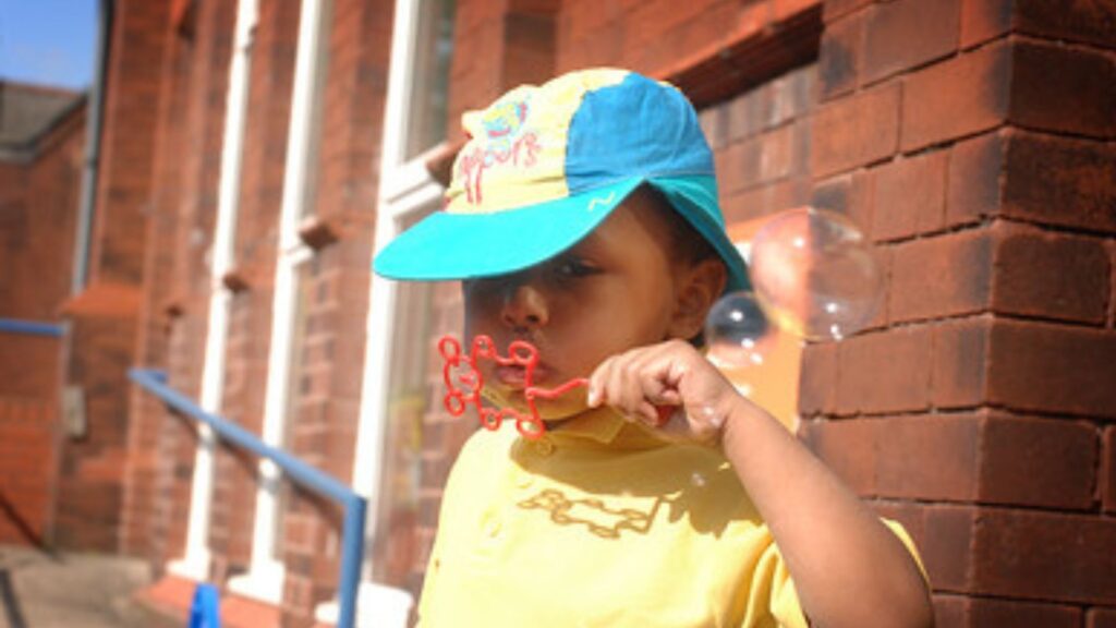 photograph of a young child blowing bubbles